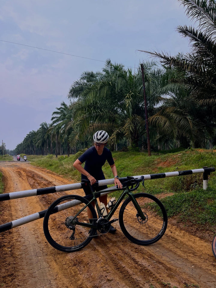 Pesepeda berdiri bersama sepeda dengan custom wheelset Strummer menggunakan rim Strummer GC25 di dekat pembatas jalan hitam-putih. Foto milik Novia Kosim (@peanutbutterno9).