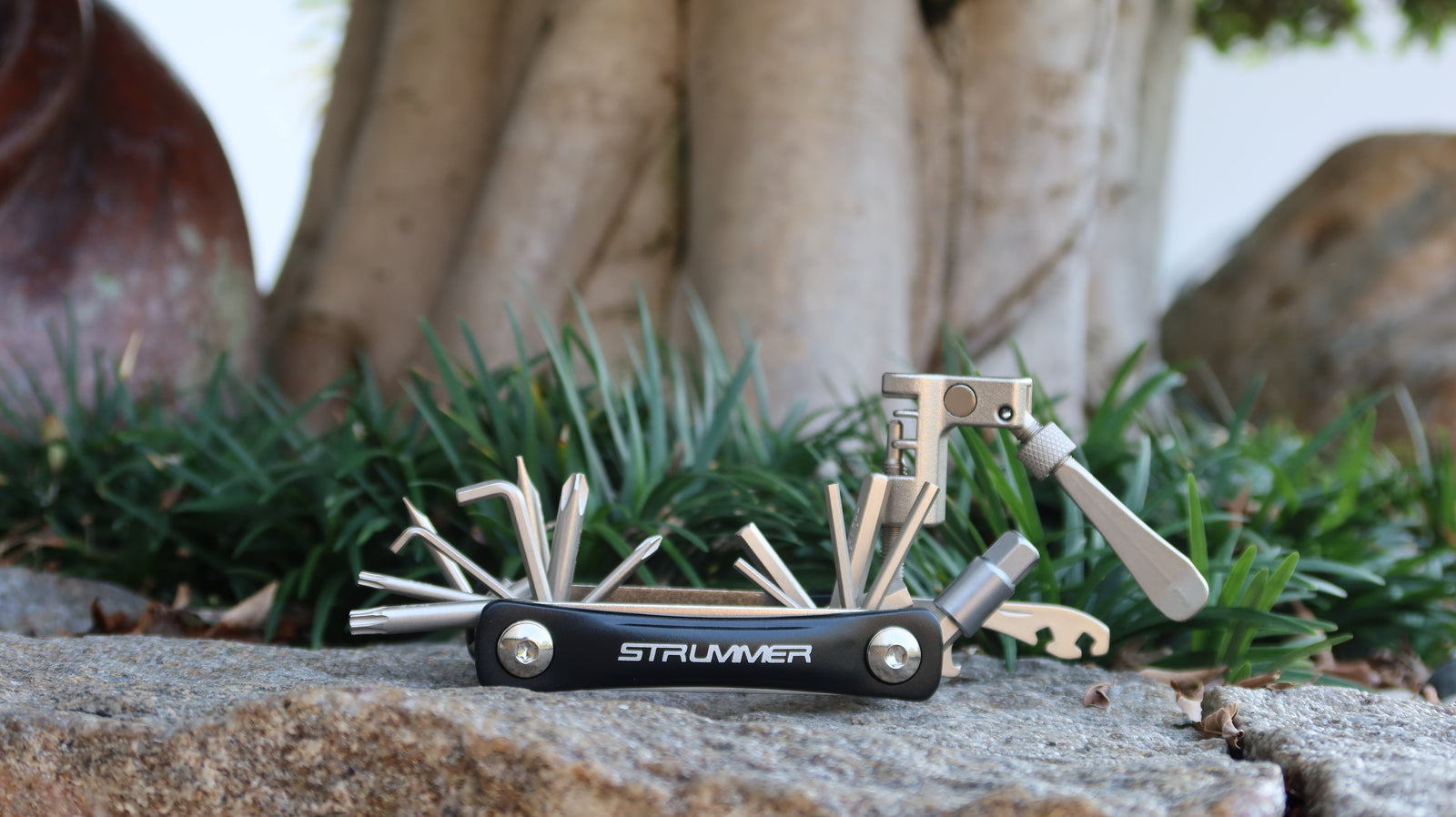 Folding Tool Strummer 20 in 1 FT-61A warna Black, terbuka di atas batu.